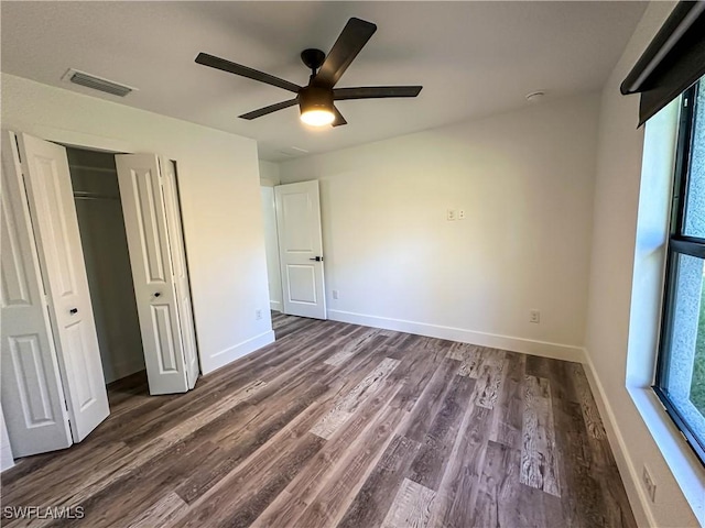 unfurnished bedroom featuring ceiling fan, dark hardwood / wood-style flooring, and a closet