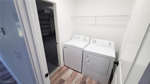 washroom with washer and clothes dryer and wood-type flooring