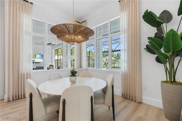 dining area featuring light hardwood / wood-style flooring and ornamental molding