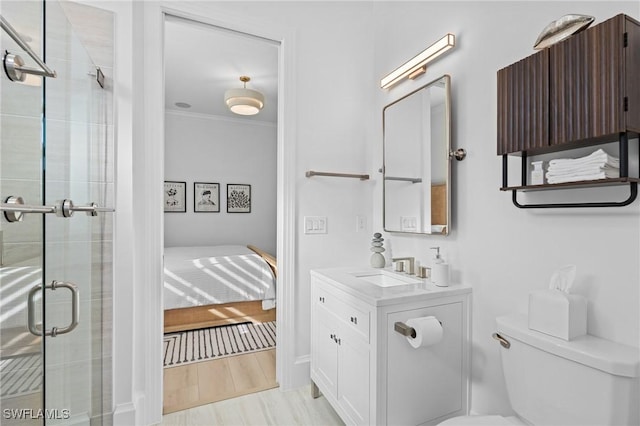 bathroom featuring vanity, crown molding, hardwood / wood-style flooring, toilet, and a shower with shower door