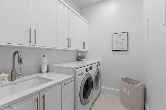 washroom with cabinets, sink, and washing machine and clothes dryer