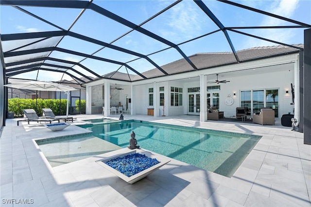 view of pool with a lanai, ceiling fan, and a patio