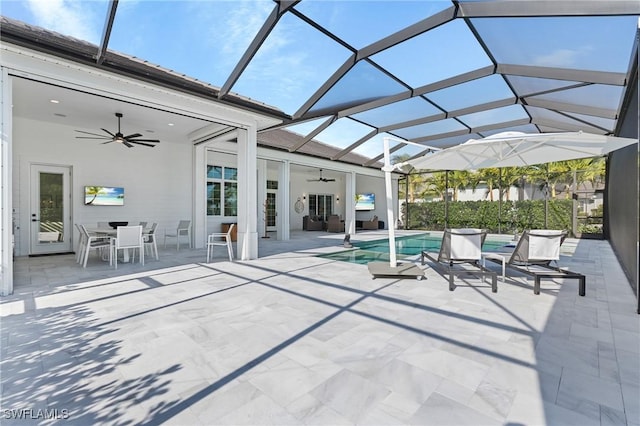 view of pool featuring glass enclosure, ceiling fan, and a patio area