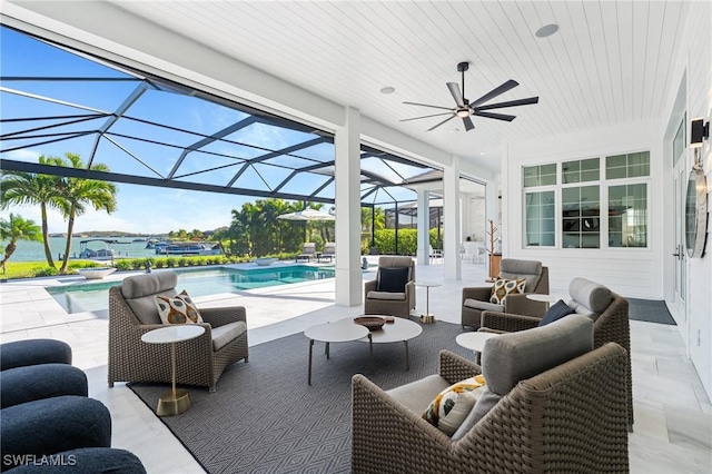 view of patio / terrace featuring an outdoor living space, ceiling fan, a water view, and glass enclosure