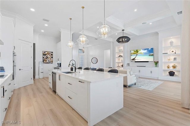 kitchen featuring a center island with sink, white cabinets, hanging light fixtures, light hardwood / wood-style flooring, and built in features