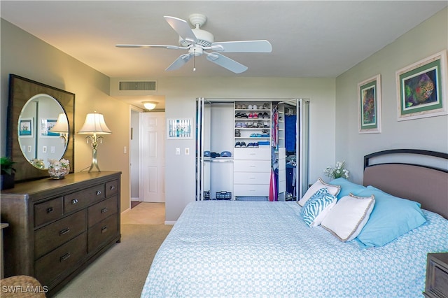 bedroom with ceiling fan, light carpet, and a closet