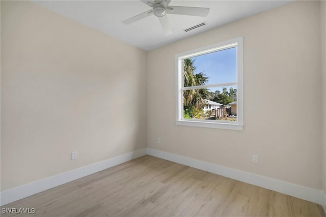 empty room with ceiling fan and light hardwood / wood-style flooring