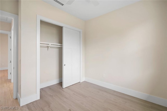 unfurnished bedroom with a closet, light hardwood / wood-style flooring, and ceiling fan