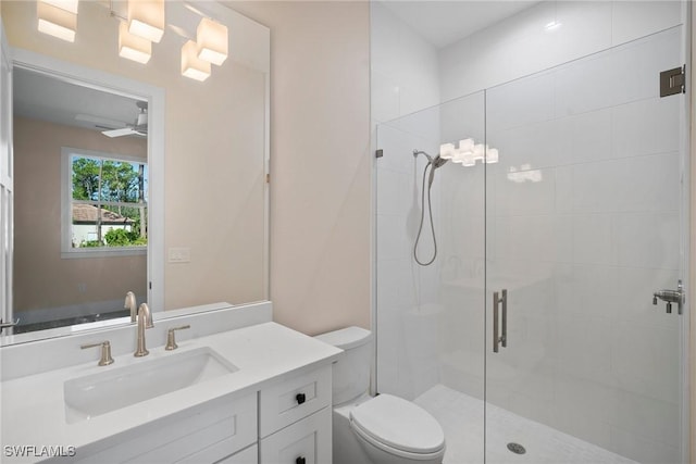 bathroom with an enclosed shower, vanity, ceiling fan, and toilet