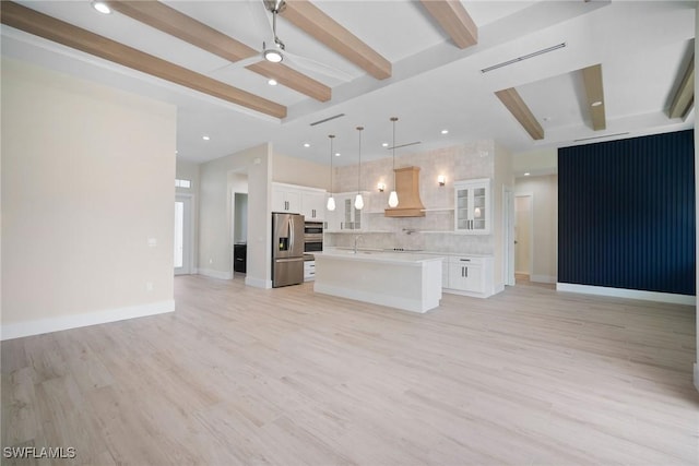 unfurnished living room featuring beamed ceiling, light hardwood / wood-style floors, ceiling fan, and sink