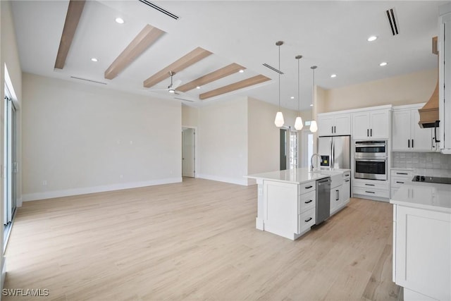 kitchen with ceiling fan, light hardwood / wood-style flooring, pendant lighting, a kitchen island with sink, and white cabinets