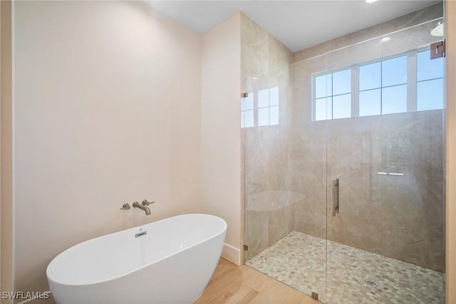 bathroom featuring hardwood / wood-style flooring and shower with separate bathtub