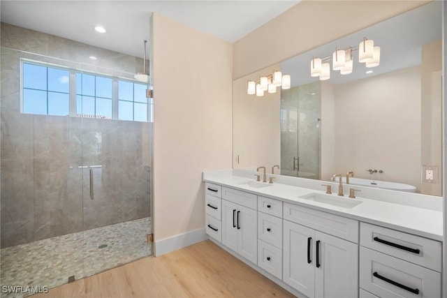 bathroom with vanity, wood-type flooring, and a shower with door