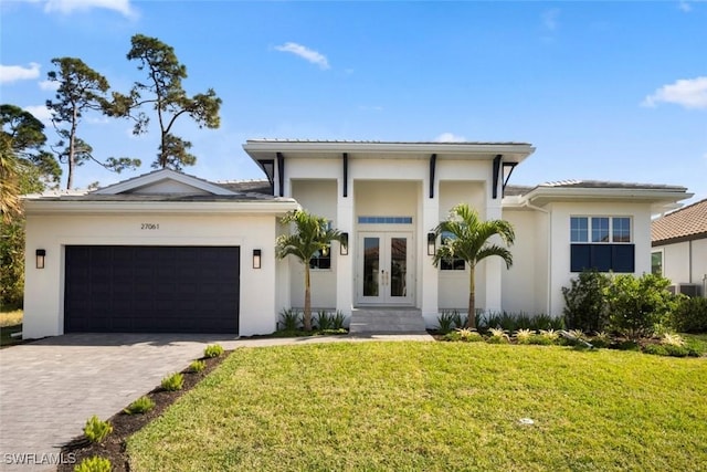 view of front facade with a front yard, french doors, and a garage