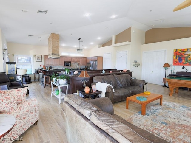 living room with high vaulted ceiling, light hardwood / wood-style floors, and billiards