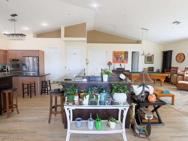 kitchen with pendant lighting, a kitchen breakfast bar, billiards, light hardwood / wood-style flooring, and stainless steel fridge with ice dispenser