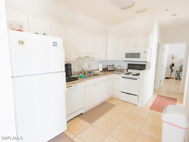 kitchen with white cabinetry, light tile patterned floors, and white appliances