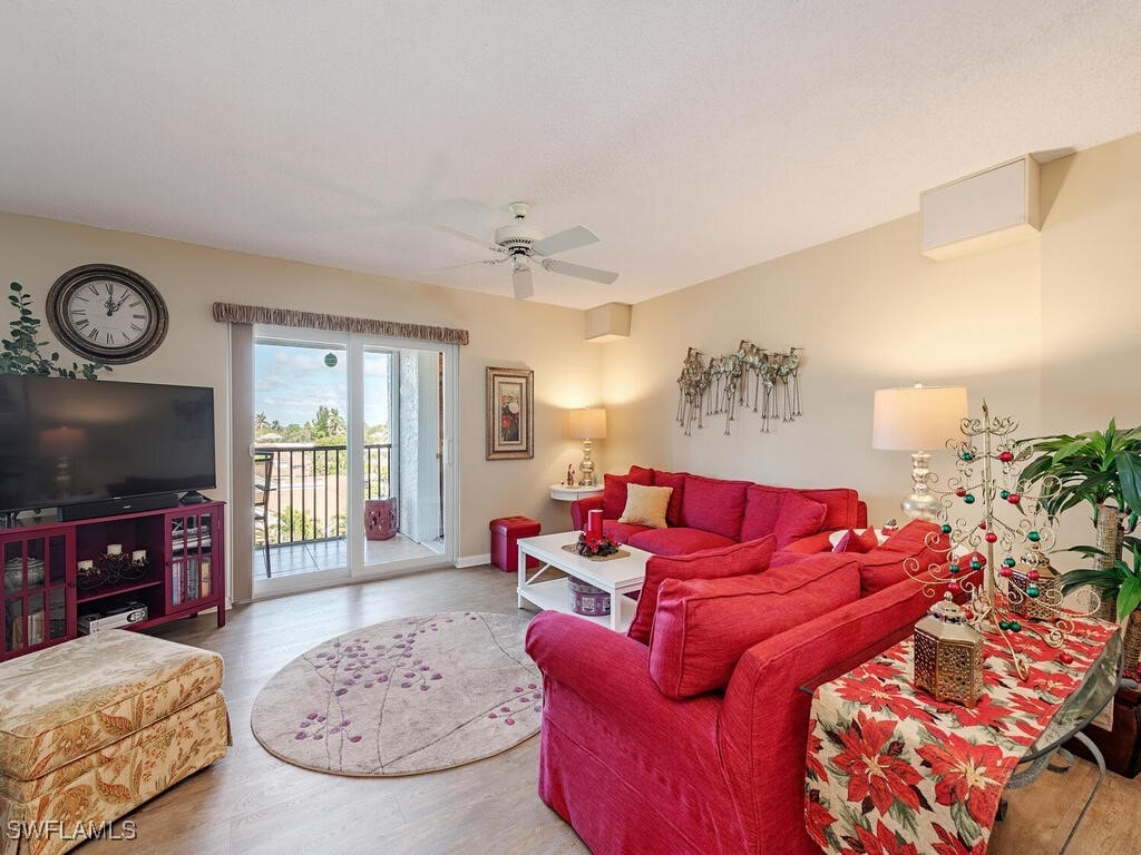 living room with ceiling fan and wood-type flooring