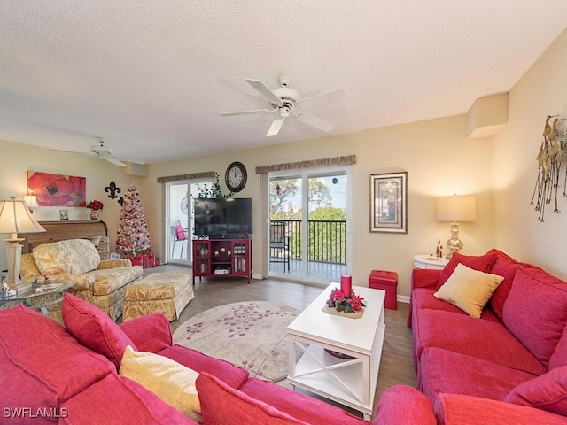 living room featuring ceiling fan and a textured ceiling