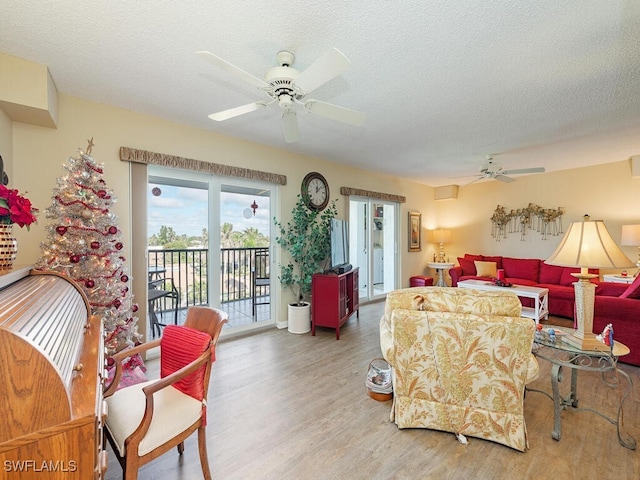 living room featuring hardwood / wood-style floors, a textured ceiling, and ceiling fan