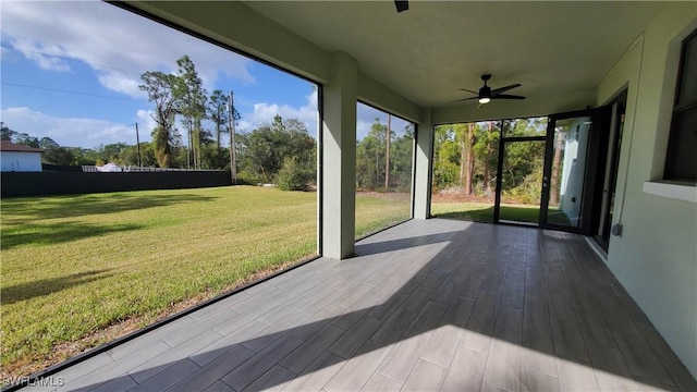 unfurnished sunroom featuring ceiling fan