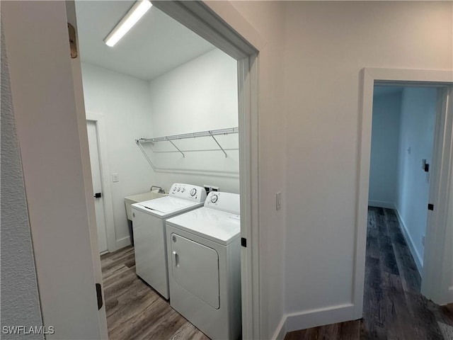 laundry area with wood-type flooring and washing machine and clothes dryer