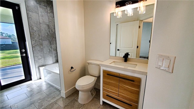 bathroom with a bathing tub, a wealth of natural light, vanity, and toilet