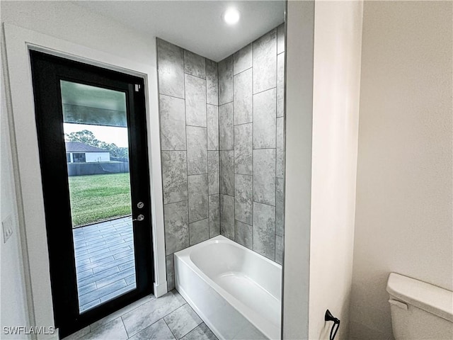 bathroom with tiled shower / bath and toilet