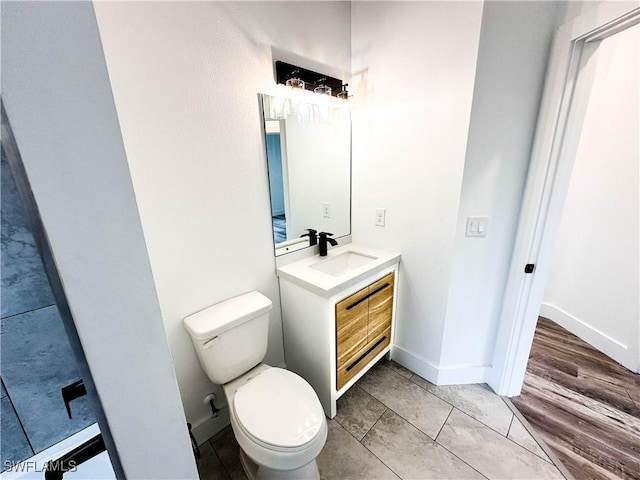 bathroom featuring wood-type flooring, vanity, and toilet