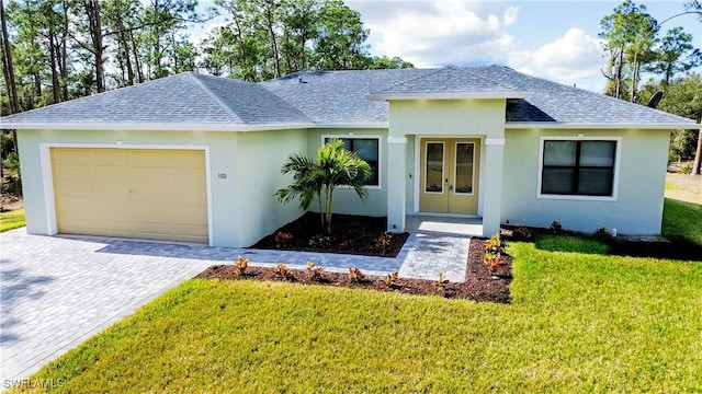 view of front of house with french doors, a garage, and a front lawn