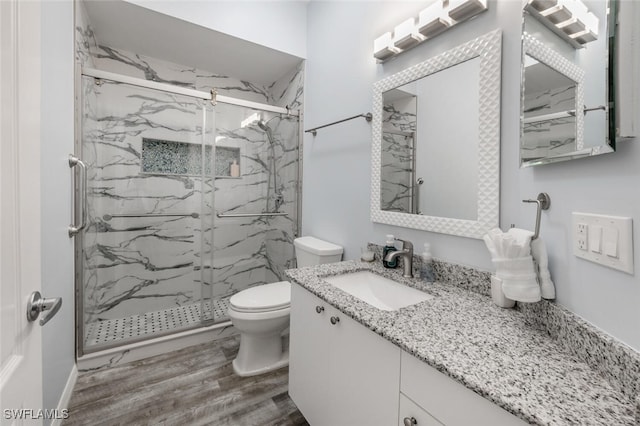 bathroom featuring vanity, hardwood / wood-style flooring, toilet, and walk in shower