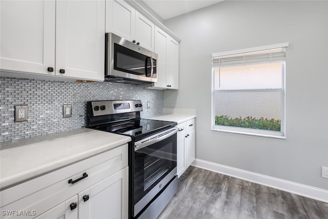 kitchen featuring backsplash, white cabinets, stainless steel appliances, and dark hardwood / wood-style floors