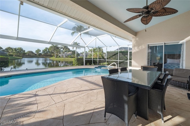 view of swimming pool featuring ceiling fan, a patio area, a water view, and glass enclosure