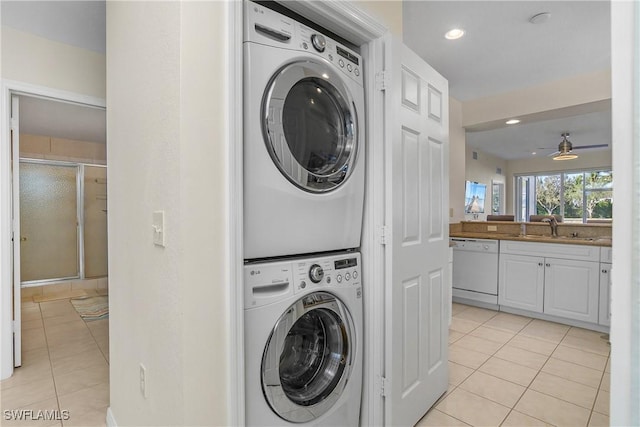 washroom with ceiling fan, sink, light tile patterned floors, and stacked washing maching and dryer