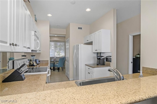 kitchen featuring white cabinetry, sink, light tile patterned floors, and white appliances