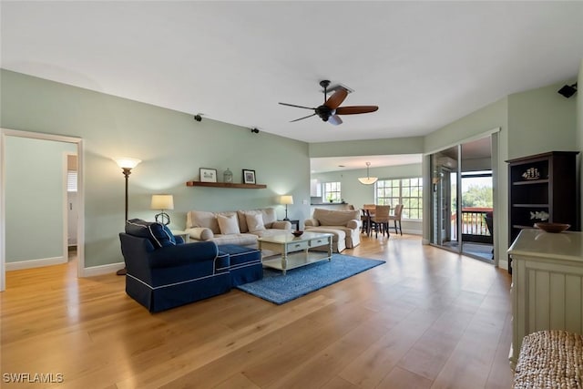 living room with ceiling fan and light hardwood / wood-style flooring