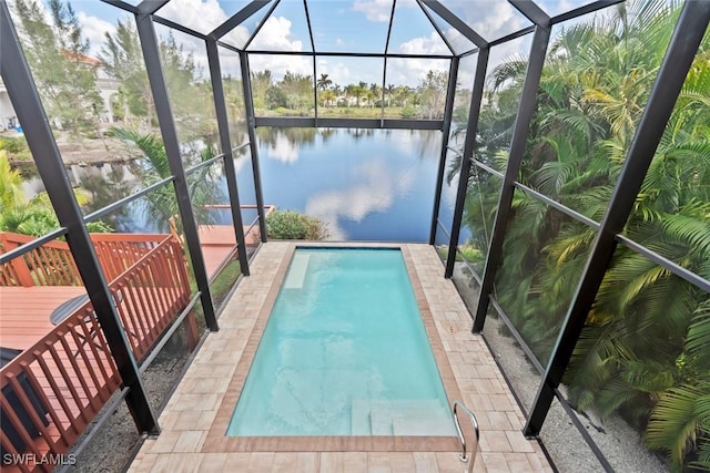 view of pool with glass enclosure and a water view