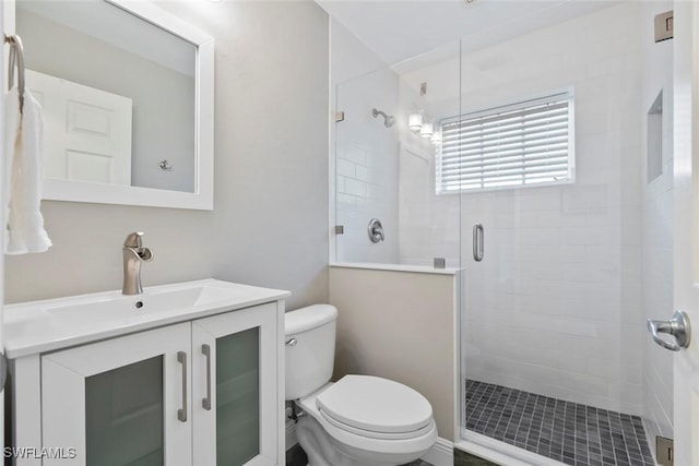 bathroom with an enclosed shower, vanity, and toilet