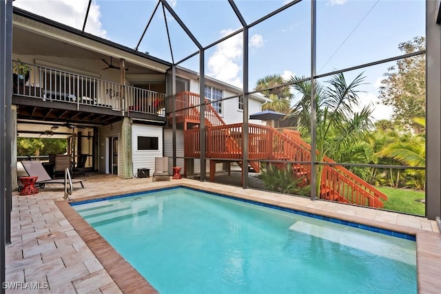 view of pool with a lanai, ceiling fan, and a patio