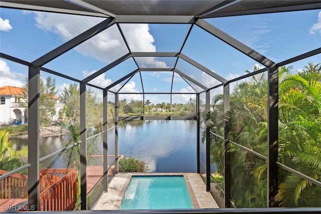 view of pool featuring glass enclosure and a water view