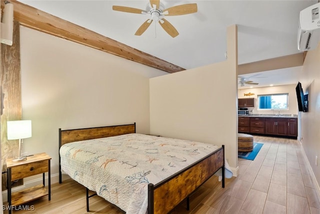 bedroom with ceiling fan, beamed ceiling, a wall mounted air conditioner, and light wood-type flooring