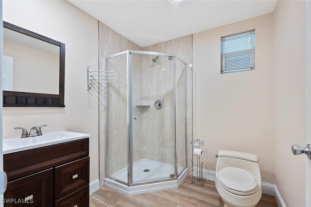 bathroom featuring vanity, toilet, and a shower with door