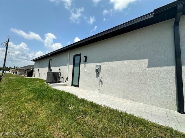 view of property exterior featuring a lawn and cooling unit