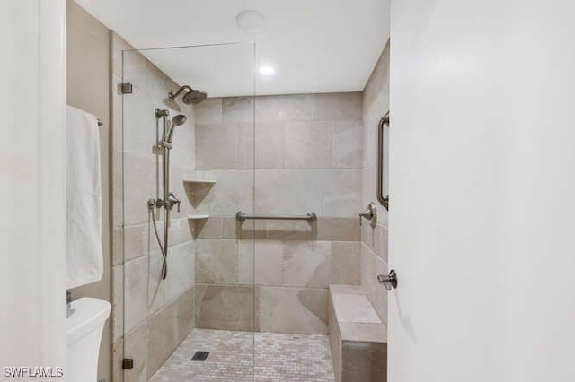 bathroom featuring toilet and tiled shower