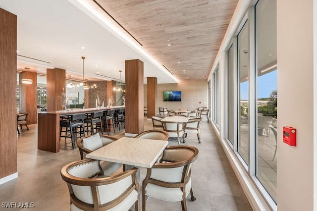 dining space featuring a notable chandelier, concrete flooring, and wood ceiling