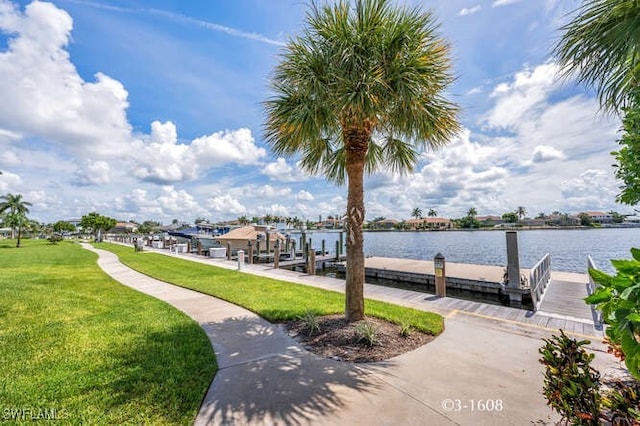 view of dock with a water view and a lawn