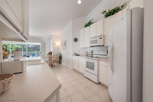 kitchen with white cabinetry, white appliances, sink, and light tile patterned floors