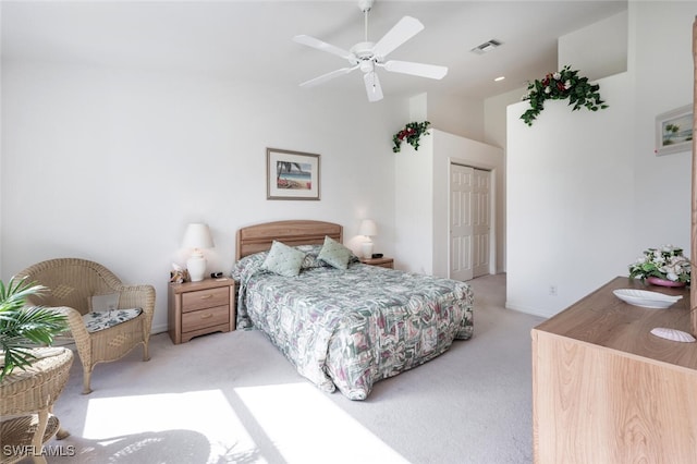 carpeted bedroom featuring ceiling fan, a towering ceiling, and a closet