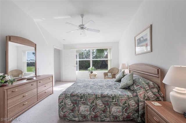 carpeted bedroom with multiple windows, ceiling fan, and vaulted ceiling