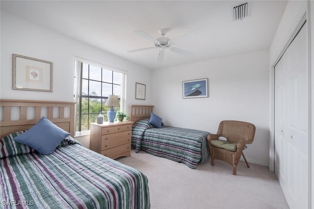 carpeted bedroom featuring ceiling fan and a closet